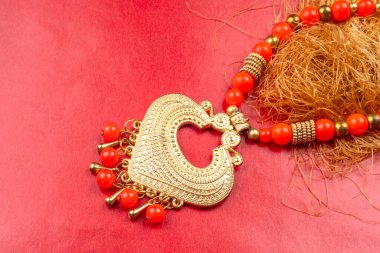Beautiful traditional indian necklace in heart form on red background