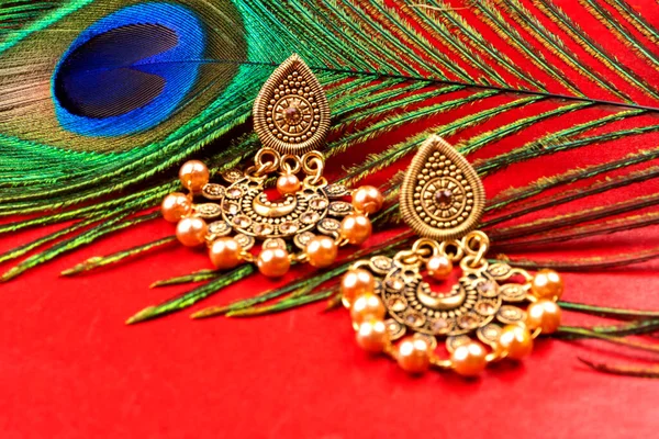 Beautiful Gold Earrings Peacock Feather Red Background —  Fotos de Stock