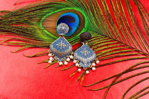 Beautiful Gold Earrings Peacock Feather Red Background — Stockfoto