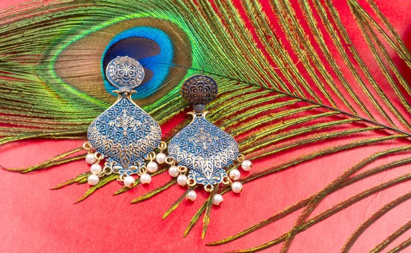 Beautiful Gold Earrings Peacock Feather Red Background —  Fotos de Stock