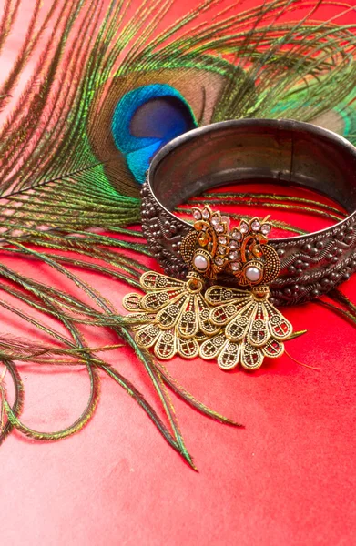 Beautiful Bracelet Earrings Peacock Feather Red Background — Stockfoto