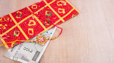 Traditional Indian jewelry with envelope and money banknotes on wooden background