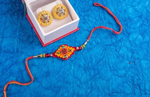 Traditional Indian jewelry with earrings on blue background