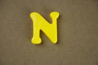 Letter N isolated on brown background