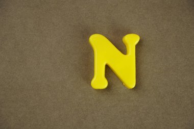 Letter N isolated on brown background