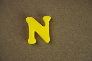 Letter N isolated on brown background