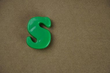 Letter S isolated on brown background 