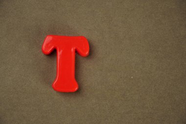 Letter T isolated on brown background