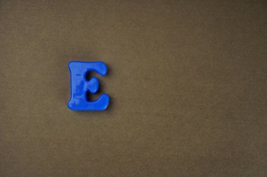 Letter E isolated on brown background