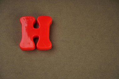 Letter H isolated on brown background