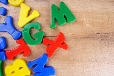 Colorful alphabet letters on wooden background