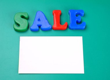 'Sale' word and white empty paper on green background