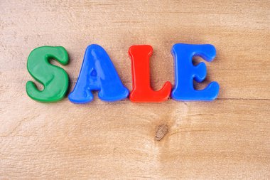 'Sale' word on wooden background