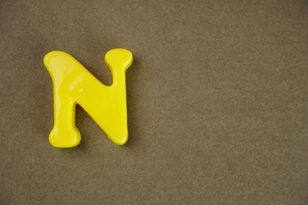 Letter N isolated on brown background