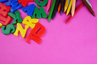 English alphabet letters and colorful pencils on pink background. Back to school. Education concept 