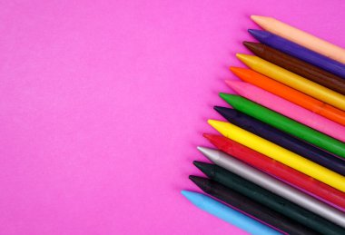 pembe arka planda renkli kalemler