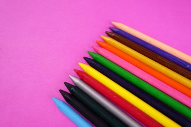 pembe arka planda renkli kalemler