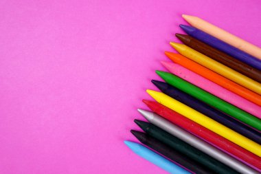 pembe arka planda renkli kalemler