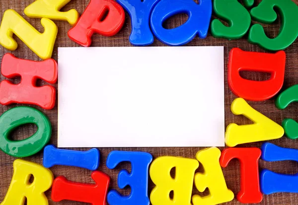 Colorful alphabet letters and empty white paper for copy space