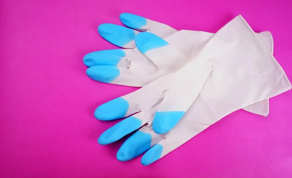 Rubber gloves on pink background
