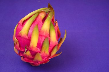 Fresh ripe dragon fruit on purple background