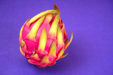 Fresh ripe dragon fruit on purple background