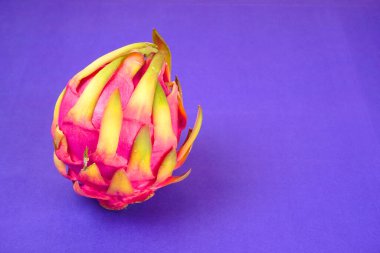 Fresh ripe dragon fruit on purple background