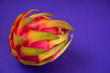 Fresh ripe dragon fruit on purple background