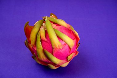 Fresh ripe dragon fruit on purple background