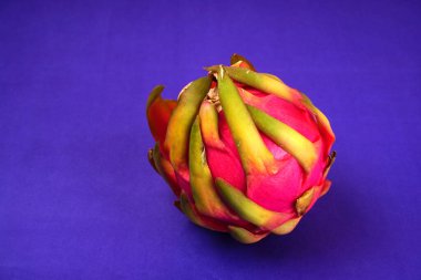 Fresh ripe dragon fruit on purple background