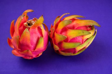 Fresh ripe dragon fruit on purple background