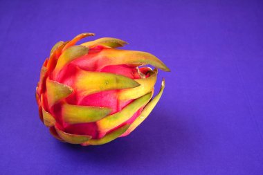 Fresh ripe dragon fruit on purple background