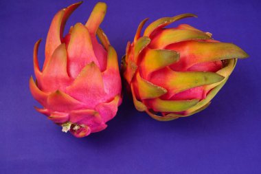 Fresh ripe dragon fruit on purple background