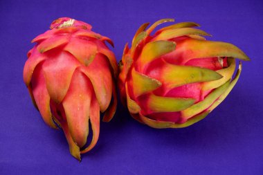 Fresh ripe dragon fruit on purple background