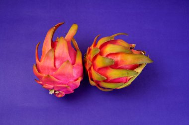 Fresh ripe dragon fruit on purple background