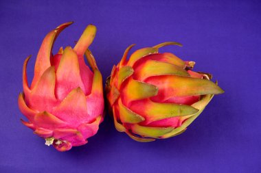 Fresh ripe dragon fruit on purple background