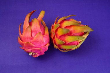 Fresh ripe dragon fruit on purple background