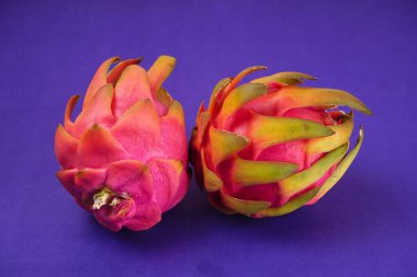 Fresh ripe dragon fruit on purple background