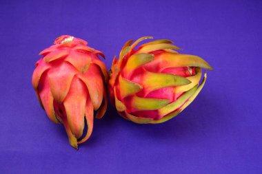Fresh ripe dragon fruit on purple background