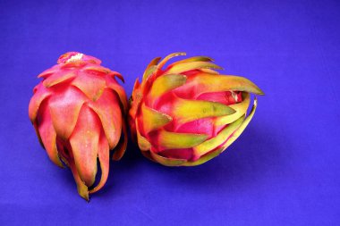 Fresh ripe dragon fruit on purple background