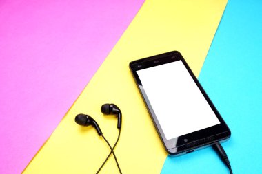 Renkli arka plan üzerinde kulaklık ile Smartphone