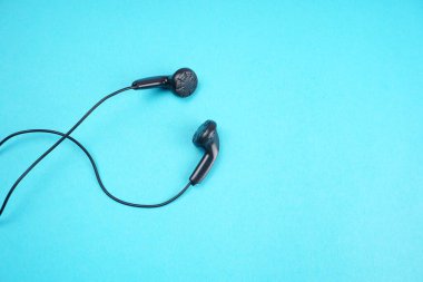 Black headphones on turquoise background