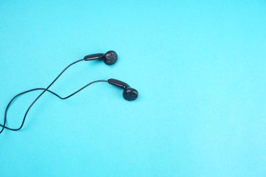 Black headphones on turquoise background