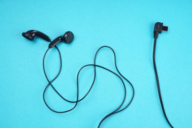 Black headphones on turquoise background