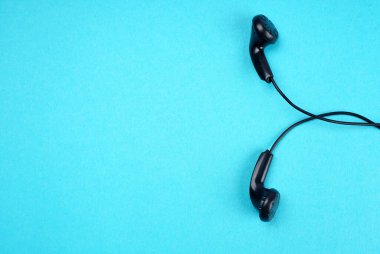 Black headphones on turquoise background