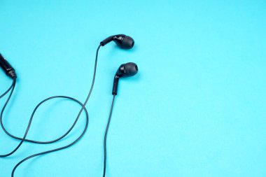 Black headphones on turquoise background