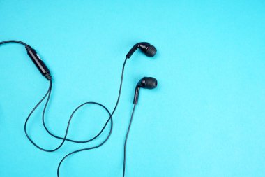 Black headphones on turquoise background