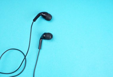 Black headphones on turquoise background