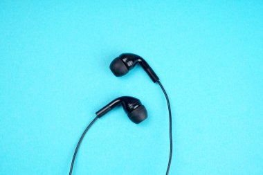 Black headphones on turquoise background