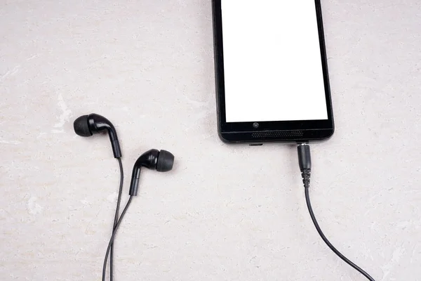 Smartphone with headphones on white background